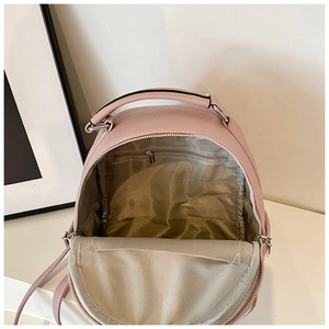 Detail view of pink leather backpack interior with chevron stitching and zipper pocket