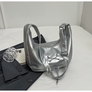 Detailed view of silver metallic Hobo bag featuring a stylish bow and adjustable strap