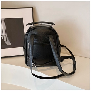 Detail of black pebbled leather mini backpack back with straps and zipper pocket