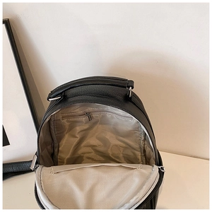 Detail of black pebbled leather backpack showing interior zipper pocket and lining