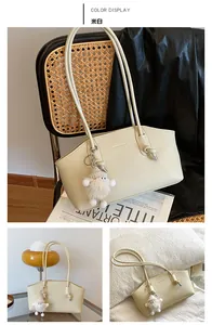 Détail d'un sac sous les aisselles beige minimaliste avec nœud et peluche suspendue