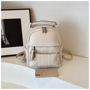 Detailed close-up of cream mini backpack with lychee texture and quilted zip pocket