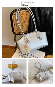 Détail du sac cabas argenté métallisé avec texture froissée et breloque en peluche
