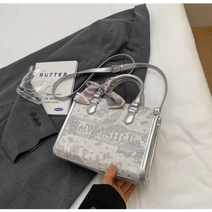 Draufsicht auf silberne Tote Bag mit Schmetterlingsdruck, Seidenschal und Schultergurt