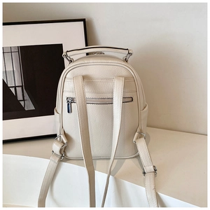 Rear view of cream PU leather mini backpack showing straps and hidden zipper pocket