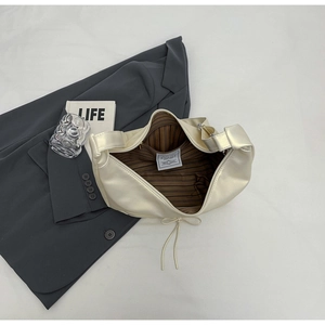 Detail of hobo bag interior showing brown striped lining and inner pocket with label
