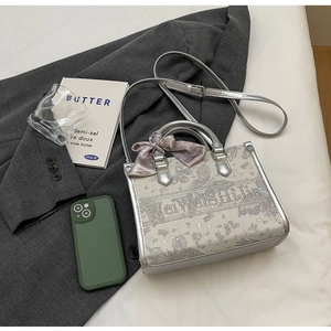 Edle Stickerei auf grauer Handtasche mit eleganter Seidenschleife und floralem Muster