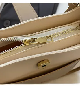 Macro shot of high-quality metal zipper and smooth magnetic buckle on beige bucket bag