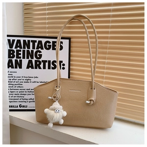 Détail du sac cabas en cuir beige avec imprimé et pendentif monstre mignon