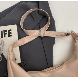 Detail of adjustable metal buckle and pink leather texture on half-moon hobo bag