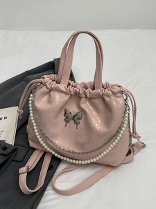 Mochila rosa brillante con detalle de mariposa y cadena de perlas decorativa