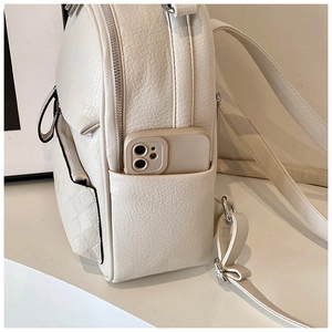 Detail of cream white leather backpack side pocket holding a smartphone as size reference