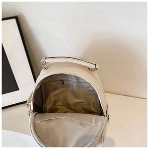 Interior view of white PU leather backpack showing zipper pocket and herringbone lining