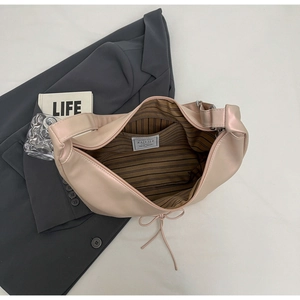 Close-up of beige tote bag interior featuring dark striped lining and internal pocket