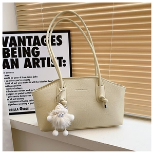 Détail d'un sac cabas crème avec texture cuir et lettrage de mode sur un rebord de fenêtre