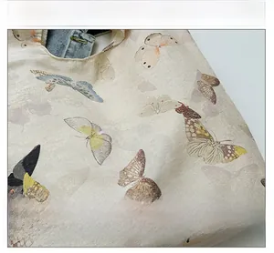 Close-up of soft beige canvas tote bag featuring realistic butterfly patterns and fine texture