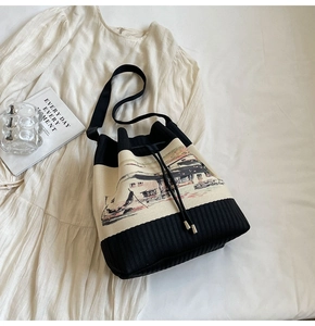 Detailansicht der Strick-Eimertasche mit Landschaftsmuster, Kordelzug und Metallspitzen