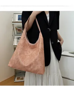 Detailed close-up showing the 3D floral embossing on this pink faux leather tote bag