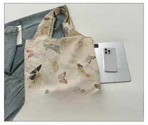 Detail view of large capacity tote bag with butterfly prints and iPad storage