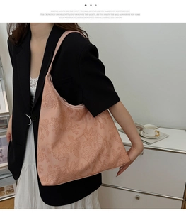 Detail of a dusty pink tote bag with elegant 3D floral embossing and shoulder strap