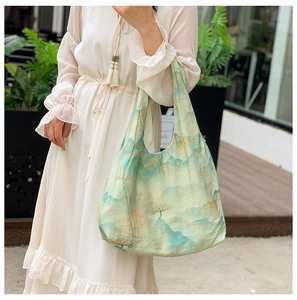 Detailed landscape print and fabric texture on a light green canvas tote bag