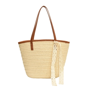 Summer straw tote bag with brown leather handles and white lace detail on white background