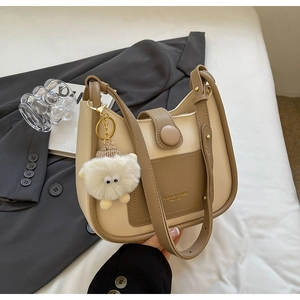 Detailed view of cream and brown patchwork bucket bag with a cute sheep charm