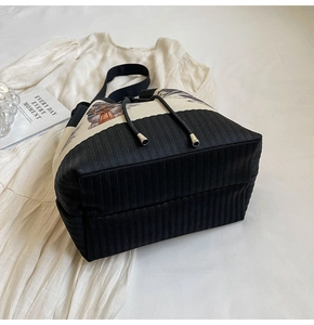 Detail der zweifarbigen Beuteltasche mit Kordelzug und gestreifter Textur