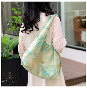Detail of light green tote bag featuring a traditional Chinese landscape painting print