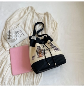 Detailansicht der gestrickten Beuteltasche mit Webstruktur und kleiner Katzenbestickung