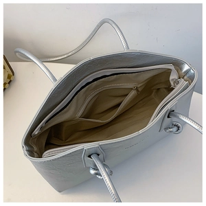 Vue de dessus de l'intérieur du sac cabas argenté avec doublure beige et poches