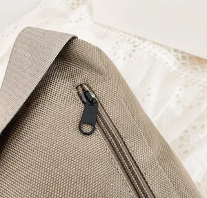 Close-up of the hidden anti-theft zipper on the back of the durable canvas crossbody bag