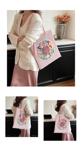 Detailed embroidery with dragon and phoenix patterns on pink woven tote bag with tassels