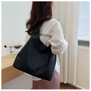 Detail view of black hobo bag featuring intricate 3D floral embossed leather texture
