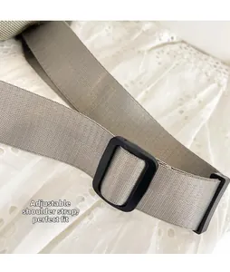 Primer plano de una correa de lona gris con hebilla de ajuste de plástico negro