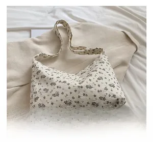 Détail du tissu gaufré texturé et du motif floral sur le grand sac cabas beige pour femmes