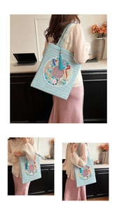 Detail of light blue woven tote with Chinese embroidery and tassel decoration
