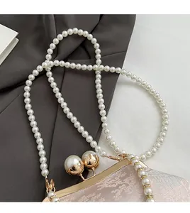 Close-up of pearl shoulder strap and vintage jacquard fabric on a pink evening bag