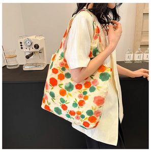Macro detail of large floral canvas tote bag with vibrant red and orange flower patterns