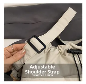 Detail of adjustable shoulder strap and drawstring toggle on beige nylon tote bag