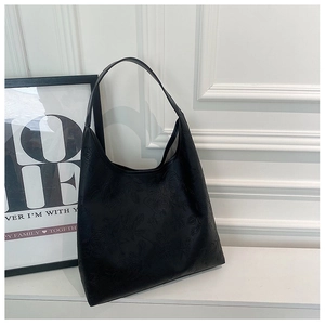Detail of embossed rose floral pattern on high-capacity black matte leather tote bag