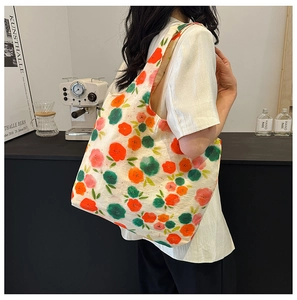 Detail of floral canvas tote bag showing abstract orange and green prints on wide straps