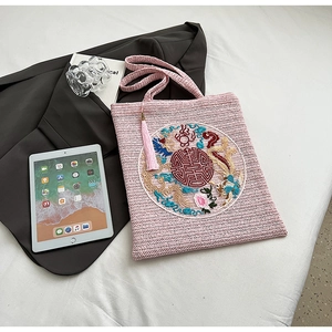 Detailed view of pink crochet tote bag featuring intricate Chinese dragon embroidery and tassels
