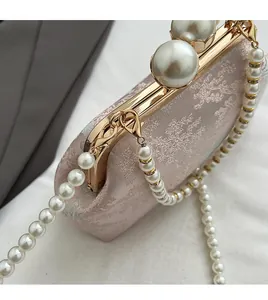 Detail view of pink jacquard embroidery bag with pearl clasp and detachable metal ring