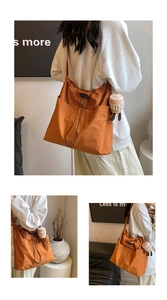 Detail view of caramel canvas tote bag showing drawstring closure and plush pendant