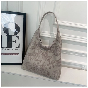 Detail of taupe shoulder tote bag featuring 3D embossed rose patterns and wide strap