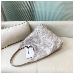 Detailed close-up of cream white tote bag with elegant embossed rose floral patterns