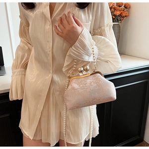 Close-up of pink Chinese brocade bag with landscape embroidery and pearl handle