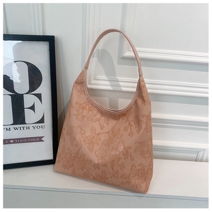 Detail showing the 3D rose flower embossed texture on the pink leather tote bag surface