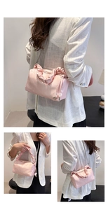 Detail of pink pleated handle handbag with silver chain and decorative beads